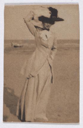 Junge Dame mit großem Hut am Strand, en face