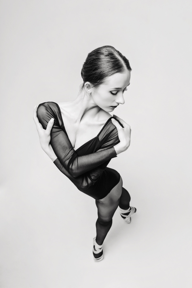 Porträt einer Ballerina in einem schwarzen Body,Draufsicht,die die Arme um die Schultern legt von Alexandr