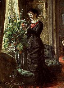 Frau Lisen Samson beim Arrangieren von Blumen vor einem Fenster 1881