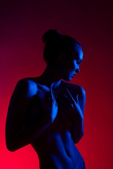 Junge Frau in lässiger Kleidung steht unter Neonlicht