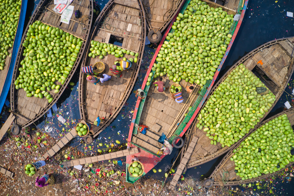 Arbeiter laden Wassermelonen mit großen Körben von den Booten von Azim Khan Ronnie