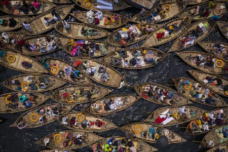 Boote voller Reisender,die den Fluss zu ihrem Arbeitsplatz überqueren
