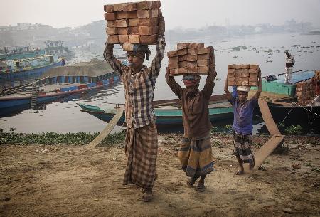 Transport von Ziegeln am Flussufer von Biruganga