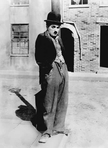A dog 's life by and with Charlie Chaplin , standing in a street, hands in pockets. Los Angeles von English Celebrities Photographer