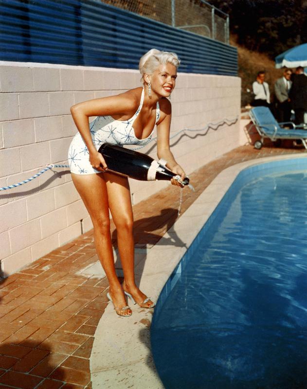 American Actress Jayne Mansfield with a bottle of champagne, near a swimming pool von English Celebrities Photographer