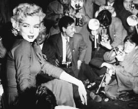Marilyn Monroe surronded by photographers c. 1955