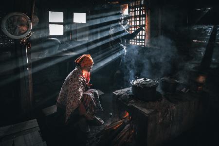 Eine Dorfoma bereitet eine Mahlzeit zu