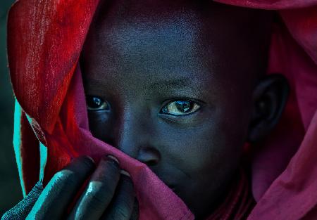 Äthiopisches Kind,bedeckt mit einem roten Gewand.