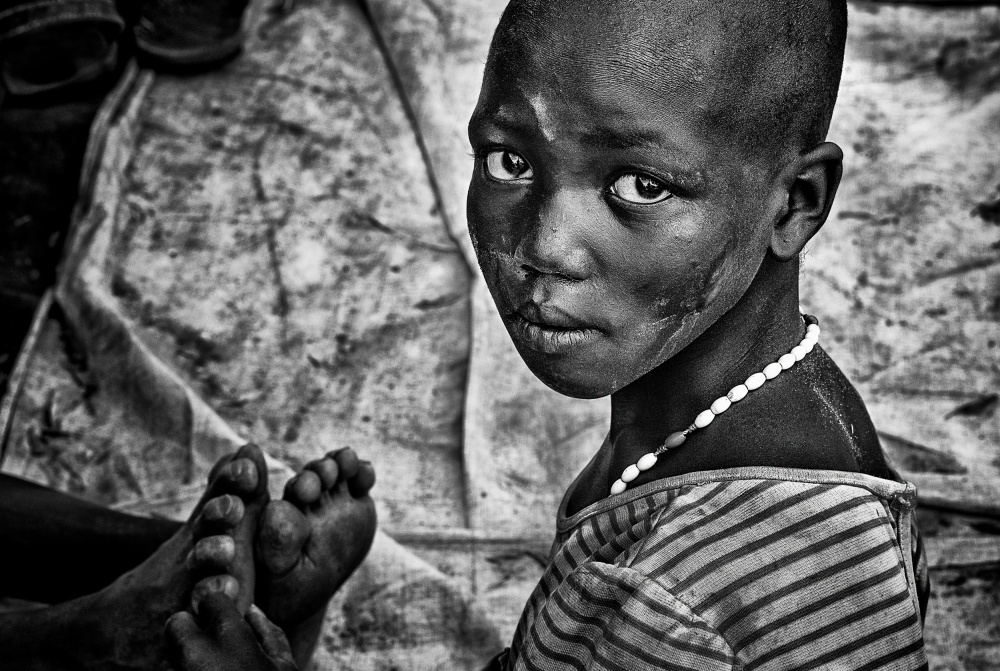 Mädchen aus dem Larim-Stamm massiert Füße – Südsudan von Joxe Inazio Kuesta Garmendia