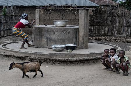 Wasser aus einem Brunnen in einem kleinen Dorf in Benin schöpfen
