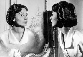 Actress Audrey Hepburn looking at her reflection in the mirror January 16