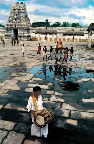 Drummer and devotees reflected in pool of water (photo)  von 