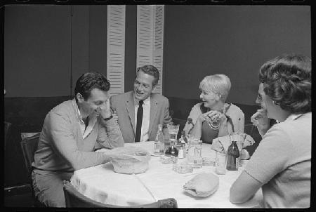 Paul Newman, Mort Sahl and Joanne Woodward joking at dinner 1964