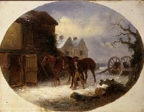 Boy leading horses to a barn in the snow